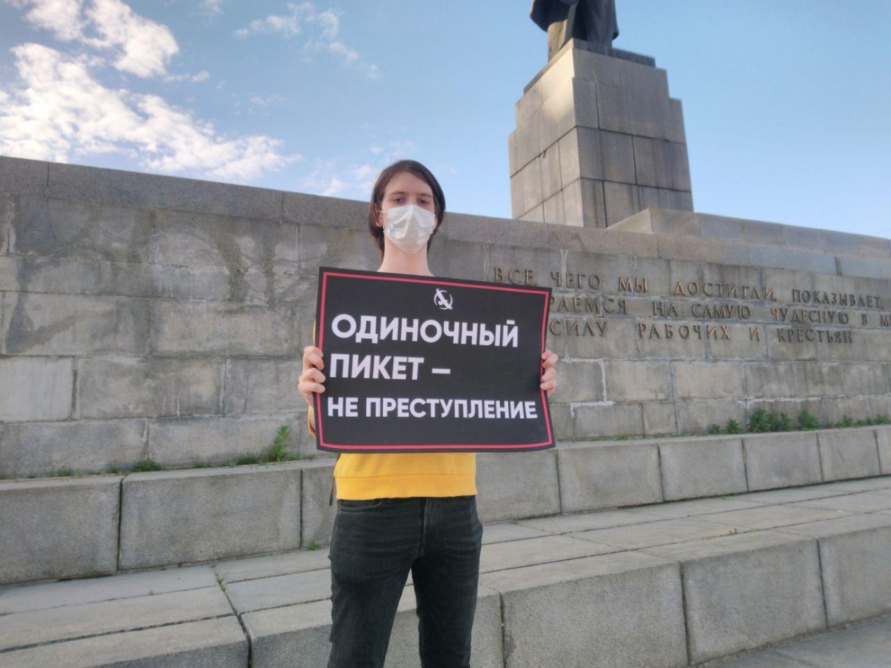 Либертарианец с плакатом "Одиночный пикет — не преступление"