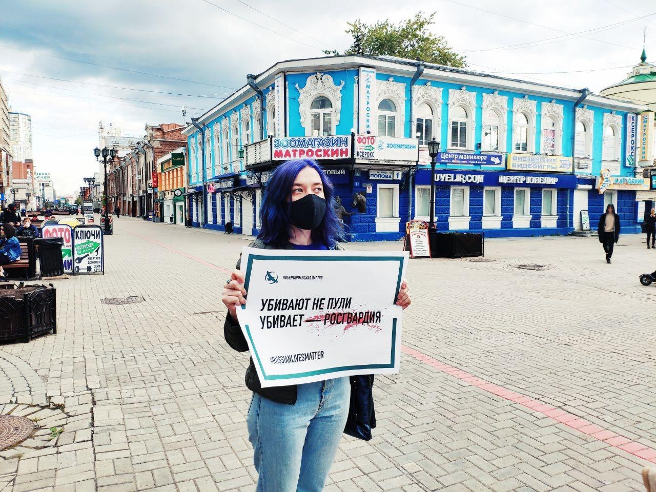 Активистка ЛПР с плакатом "Убивают не пули, убивает Росгвардия"